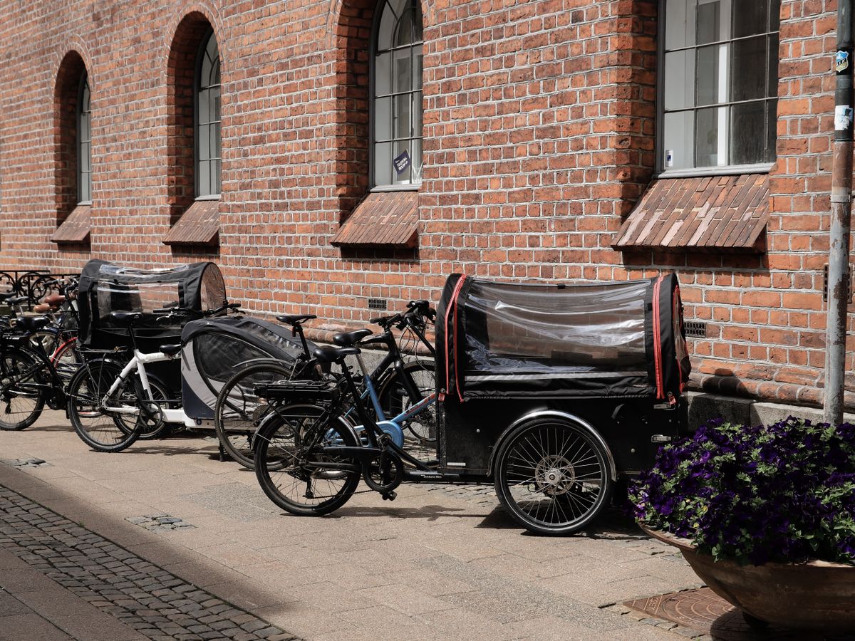 Rad av lådcyklar parkerade utanför ett bostadshus